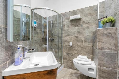 a bathroom with a sink and a glass shower at Cosy modern city centre flat in Edinburgh