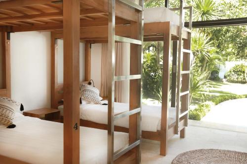 a bedroom with two bunk beds and a window at Wave House - Surf Camp in Canggu