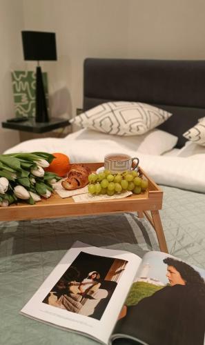 stolik kawowy z tacą z owocami i czasopismem w obiekcie Luxury Room Well Located w mieście Częstochowa