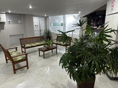 a lobby with benches and potted plants in a building at Apê da Cris - Centro BC , 5min da praia - ideal para casais , com garagem in Balneário Camboriú