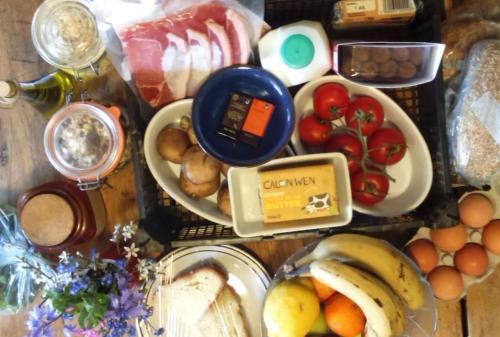 einen Tisch mit verschiedenen Frühstücksvarianten in der Unterkunft The Cwtsh at Ffynnon Clun: unique. in Goodwick