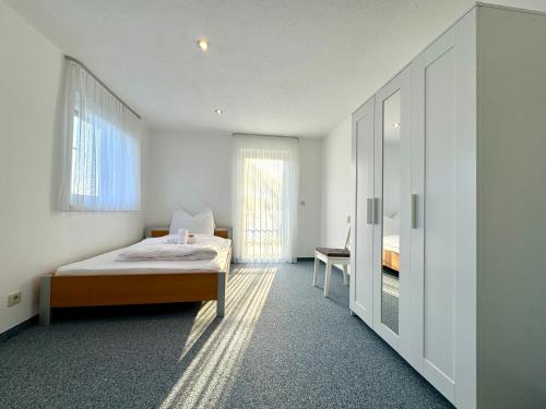 1 dormitorio con 1 cama y 1 silla en Ferienhaus 80er Liebe mit Whirlpool, en Lustenau