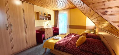sypialnia z łóżkiem i krzesłem w pokoju w obiekcie Jurika Liptov w Liptowskim Mikulaszu