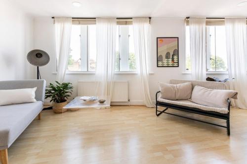 uma sala de estar com um sofá e uma mesa em Loft-style apartment with large roof terrace em Londres