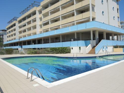 a large swimming pool in front of a building at Functional 1 bedroom apartment with shared pool in Bibione