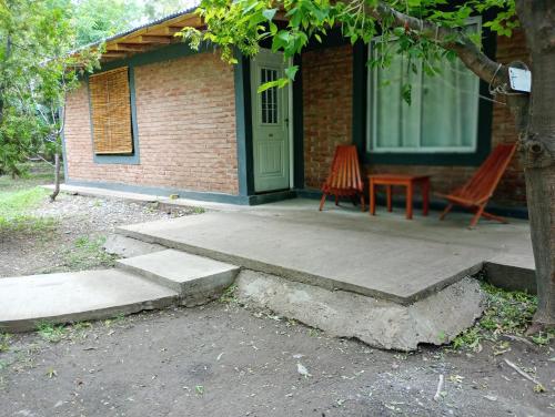 eine Veranda eines Hauses mit zwei Stühlen und einer Tür in der Unterkunft Cabañas lunita 2 in San Rafael