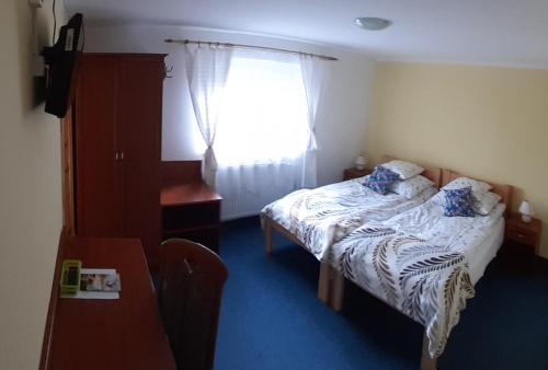 een kleine slaapkamer met een bed en een raam bij Apartament 103 in Karpacz