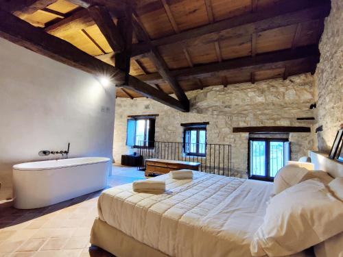 a bedroom with a large bed and a bath tub at Castel Di Luco in Acquasanta Terme