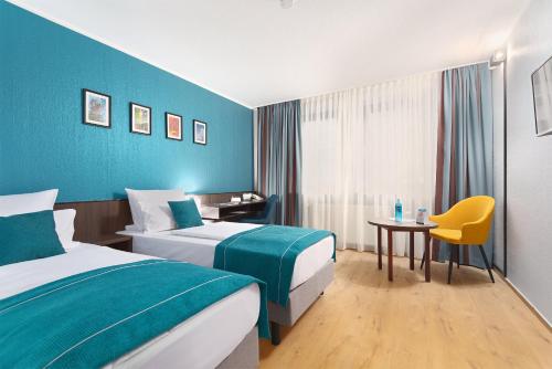 a hotel room with two beds and a table at Trip Inn Hotel Krefeld in Krefeld