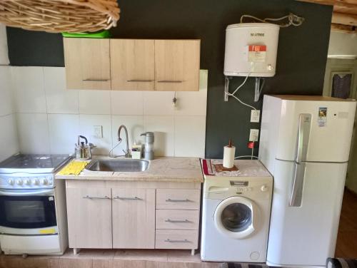 eine Küche mit einem Kühlschrank und einer Waschmaschine in der Unterkunft Cabañas lunita 2 in San Rafael