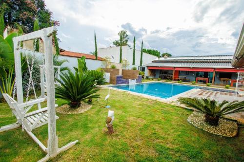 un patio trasero con piscina y una casa en chácara do Rafael, en Pilar do Sul