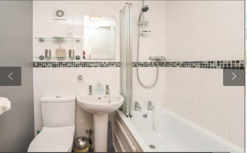 a bathroom with a sink and a toilet and a tub at 73 Palm Lodge in Kingsdown