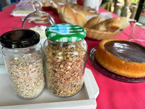zwei Masongläser voller Nüsse und Brot auf dem Tisch in der Unterkunft Pitaya Suítes in Cunha