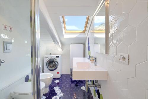 een badkamer met een wastafel en een wasmachine bij Un oblò sul mare in Maiori