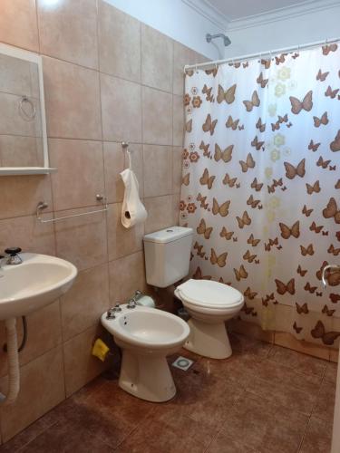a bathroom with a toilet and a sink and a shower curtain at Tesoro Escondido in Santa Rosa