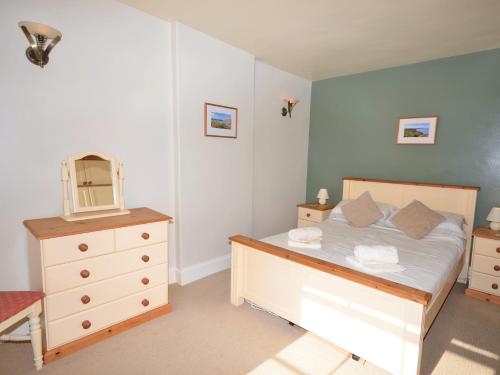 ein Schlafzimmer mit einem Bett mit einer Kommode und einem Spiegel in der Unterkunft 1 Bed in Appledore CAPTV in Appledore