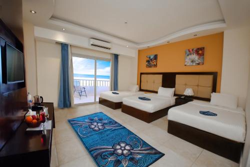 a hotel room with two beds and a balcony at LUSINDA HOTEL MANAGEMENT BY ZAD in Suez