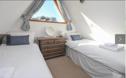 two twin beds in a room with a window at 73 Palm Lodge in Kingsdown