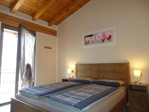 Un dormitorio con una cama grande y una ventana. en Casa Carla, bis 4 Personen, Garten, Balkon mit Blick auf den See und die Berge, en Crone