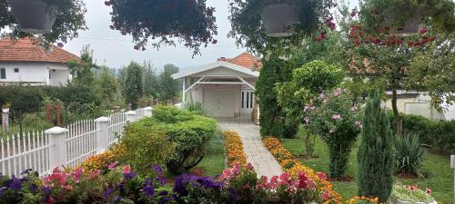 una cerca blanca frente a un jardín con flores en Holiday Home Peaceful Retreat, en Visoko