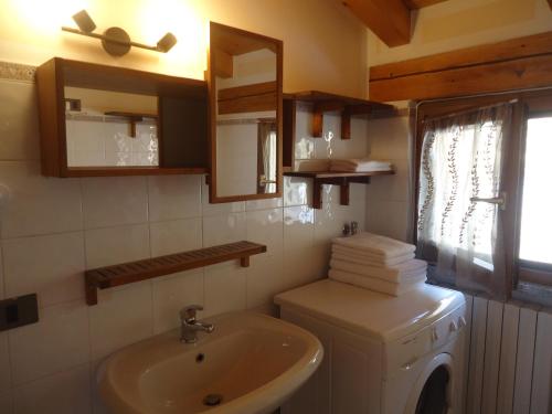 a bathroom with a sink and a washing machine at Casa Carla, bis 4 Personen, Garten, Balkon mit Blick auf den See und die Berge in Crone