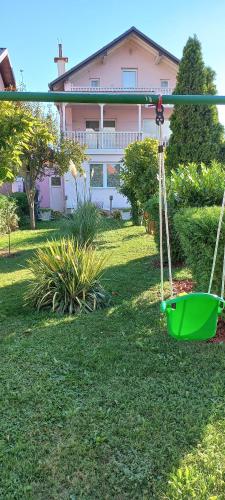 a green swing in the yard of a house at Holiday Home Peaceful Retreat in Visoko