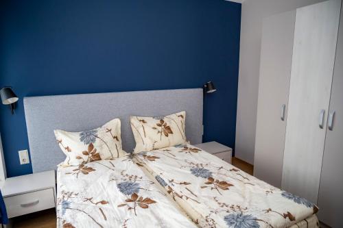 a bedroom with a bed with a blue wall at Villa Doma in Sapareva Banya