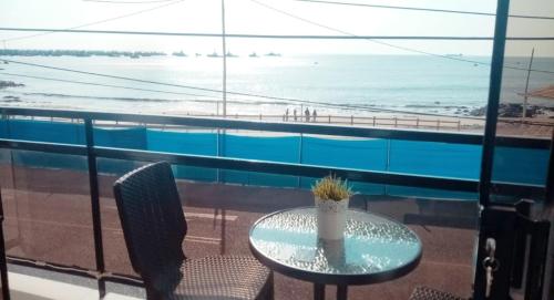 - Balcón con mesa y sillas y vistas a la playa en Departamento Frente al Mar, en Ilo