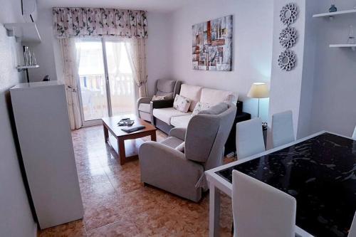 a living room with a couch and a table at Appartement Hola Playa Torrevieja in Torrevieja