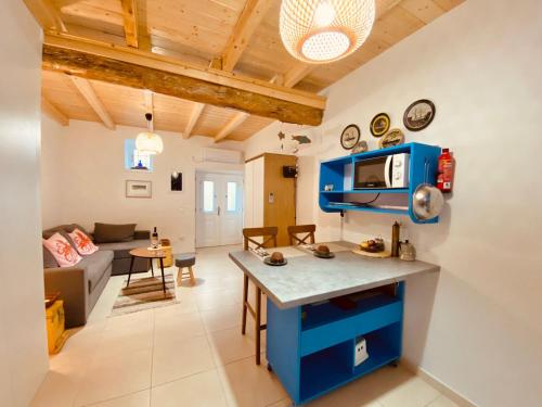een keuken en een woonkamer met blauwe kasten en een bank bij Malta House in Galaxidi in Galaxidhion