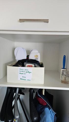 a white box on a shelf with shoes at Appartement meublé à louer à Nax in Nax