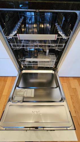 a dishwasher with its door open with dishes in it at Appartement meublé à louer à Nax in Nax