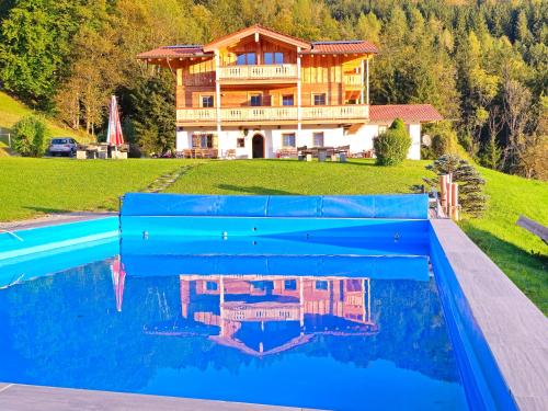 uma casa com piscina em frente a uma casa em Ferienwohnungen Angerer Kederlehen em Berchtesgaden