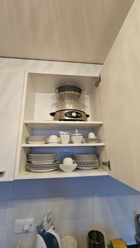 a shelf with plates and bowls and a pot at Appartement meublé à louer à Nax in Nax