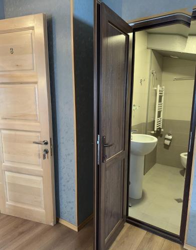 a bathroom with a toilet and a glass door at Bala's House in Mestia