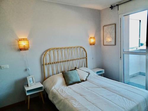 a bedroom with a bed with two tables and a window at Sui Generis penthouse with terraces in Milan