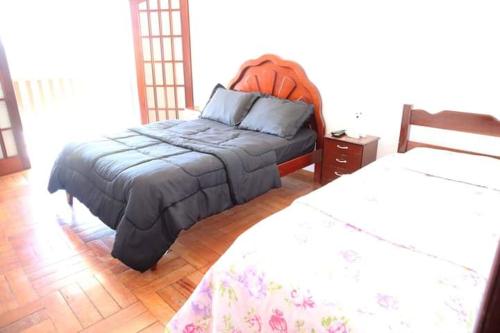 - une chambre avec deux lits et un couvre-lit dans l'établissement Casa em Águas de Lindóia, à Águas de Lindóia