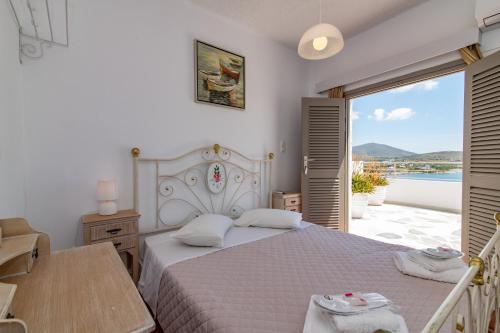 sypialnia z łóżkiem i widokiem na ocean w obiekcie Agali bay hotel w mieście Tinos