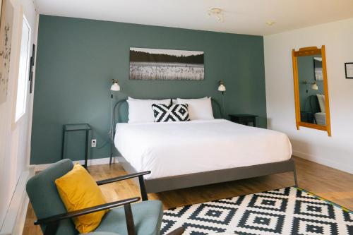 a bedroom with a bed and a green wall at Beatnik Hotel in Bromont