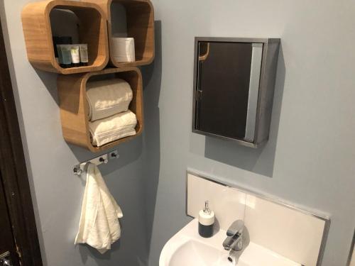 a bathroom with a sink and a mirror and towels at The Old Bath Arms in Frome