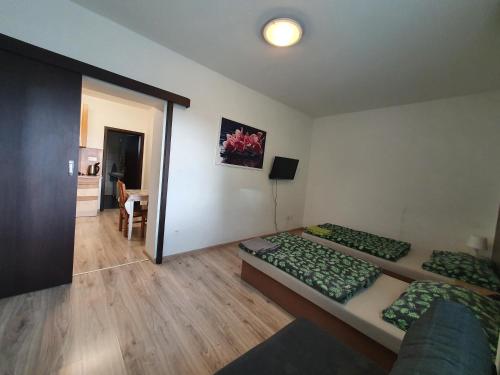 a room with two beds and a table in it at UBYTOVANIE NITRA – Lužianky Privát Iveta in Šarlužky-Kajsa