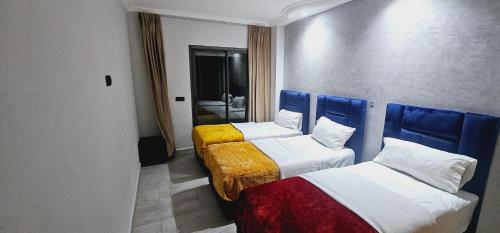 um quarto com duas camas em azul e branco em Apartment Tangier City Cornice em Tânger