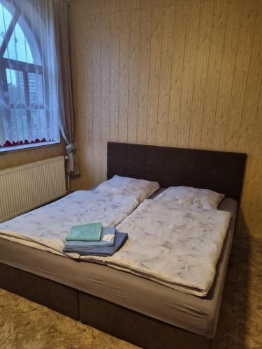 a bed with a book on it in a room at Studánka in Orlová