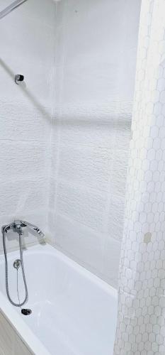uma banheira branca com uma cortina de chuveiro na casa de banho em Apartment Tangier City Cornice em Tânger