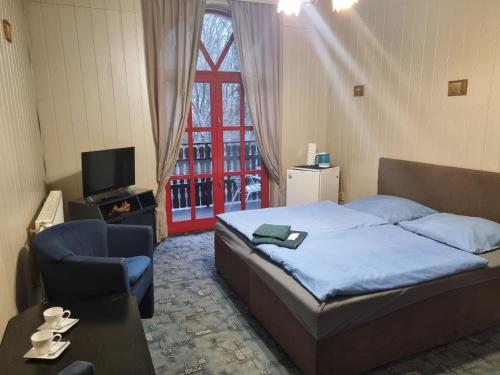 1 dormitorio con 1 cama, 1 silla y 1 ventana en Studánka, en Orlová