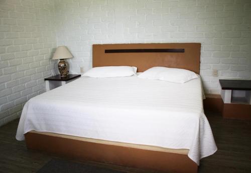 - une chambre avec un grand lit et des draps blancs dans l'établissement Mama Chuy Hotel & Villas, à San Juan Cosalá