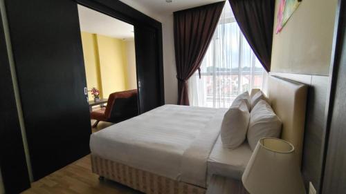 a hotel room with a bed and a window at MetraSquare 308 Easy Suite in Malacca