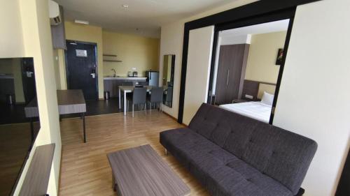 ein Wohnzimmer mit Sofa und ein Schlafzimmer in der Unterkunft MetraSquare 308 Easy Suite in Malakka