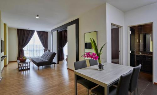 ein Wohnzimmer mit einem Tisch, Stühlen und einem Sofa in der Unterkunft MetraSquare 308 Easy Suite in Malakka