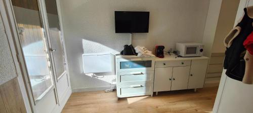 Cette chambre dispose d'un bureau, d'un four micro-ondes et d'une télévision. dans l'établissement Le Hameau, à Allos